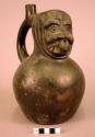 Ceramic bottle, stirrup spout, molded face with a nose ring