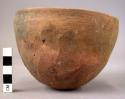 Ceramic bowl, coarse red ware, rounded base, straight sides, incised