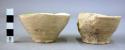4 undecorated pottery cup fragments; 1 undecorated pottery cup     4 in tray  E.