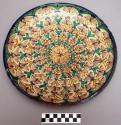 Ceramic plate; polychrome (blue, yellow, green, brown on a buff color) glossy