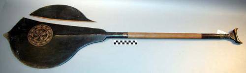 Paddle with black pigment, carved handle