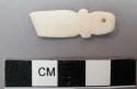 Piece of carved cardium shell with single perforation. 3.1 x 1 cm.