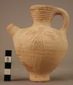 Narrow necked side spouted pottery vessel - stem footed; vertical parings; incis