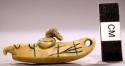 Carving of figure in kayak, ivory. Perforation indicates use as amulet.