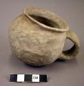 Ceramic cup, small, undecoraed grey ware, strap handle, flared rim
