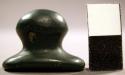 Ground nephrite labret. Head is flared and concave. Shaft is grooved, round.