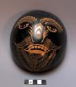 Carved gourd mask, painted black, with yellow, green & purple features