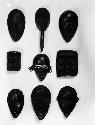 9 small black wooden masks, replicas of larger masks, decayed or destroyed