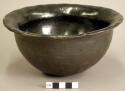 Small pottery bowl. Deep with flaring rim, polished black ware, undecorated.