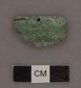 Fragment of low relief jadeite head- cylindrical rim perforation, carved on both