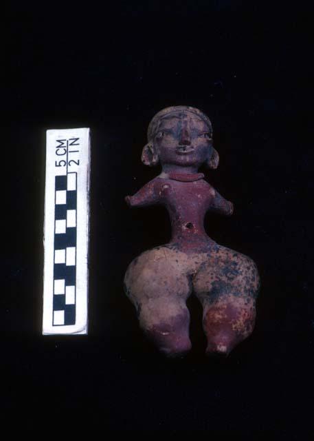 Clay figurine, type "D-4", with remains of red and yellow paint. Female figure.