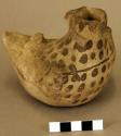 Pottery vessel, somewhat in shape of headless bird, grey with black spots. blac