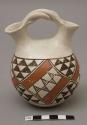 Wedding vase with twisted handle, black and red design; signed G. Chino / Acoma, N. M