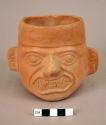 Ceramic cup, human effigy, molded face, fangs, earplugs