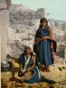 Hopi woman weaving a basket, with a girl standing behind her