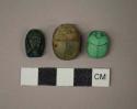 Ground stone ornaments, 2 scarab amulets and one fish amulet