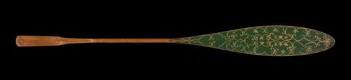 Canoe paddle, elaborately decorated. Blade painted green, double curve motif.