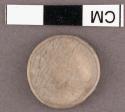 Burned shell disk--cardium? 1.9 cm. d. x <.2 cm. thick.
