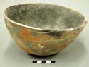 Bowl. outcurved. round bottom. rim chipped; otherwise intact; small fire-clouds.