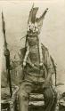 Thompson River Indian man "Alexander KwikweiteskEt " in costume, including feather headdress and spear