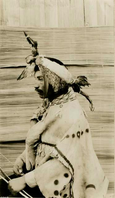 Thompson River Indian in native costume, including a headdress of loon skin.