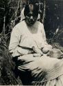Pomo weaver, Lake, California with basket in her lap