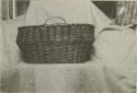 Photograph of basket with several strands of reddish stained reeds, known to be at least 90 yrs old. From Bristol, R.I.

