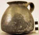 Ceramic jar, 1 strap handle, flaring rim, chipped, round body, black ware