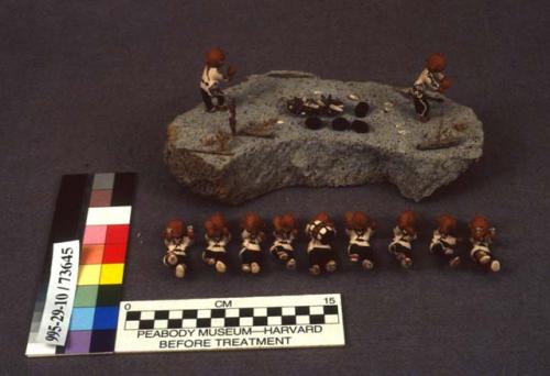 Scene of ceramic mudhead figures on volcanic rock