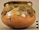 Ceramic jar, round body and base, flaring pinched rim, filleted floral design