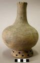 Ceramic complete vessel, long neck, footed ring that is decorated with perforati