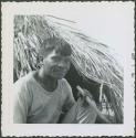 Photograph album, Yaruro fieldwork, p. 50, photo 1, man in front of thatched building