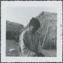 Photograph album, Yaruro fieldwork, p. 51, photo 2, man sitting outside thatched building