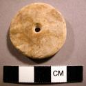 Ground stone ornament, perforated disc