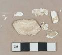 White shell fragments, heavily degraded