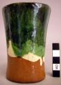 Ceramic cup, flat base, cylindrical body, flaring rim, orange, green, buff glaze