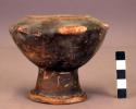 Black pottery bowl, annular base, effigy