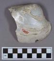 Organic, utilized shell fragment, carved and shaved ventral margin