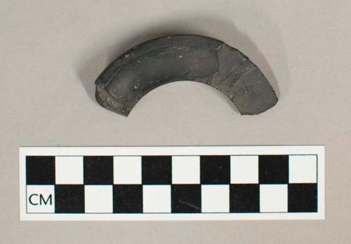 Fragment of black slate spool shaped ear ornament