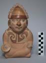 Ceramic bottle, stirrup spout, human effigy, molded face, body, arms, and legs,