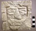 Ground stone sculpture, carved human facial features & headdress, chipped