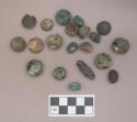 Ceramic or stone domed objects and fragments, grooved on flat side, some covered with copper alloy; copper alloy beads, ovoid
