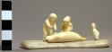 Ivory carving - man bent over seal, woman with baby and small child