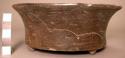 Almost complete lightly incised black flat-bottomed flaring-sided pottery bowl