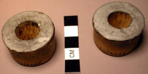 Pair of wooden ear plugs - tin attached to one end; perforated; worn +