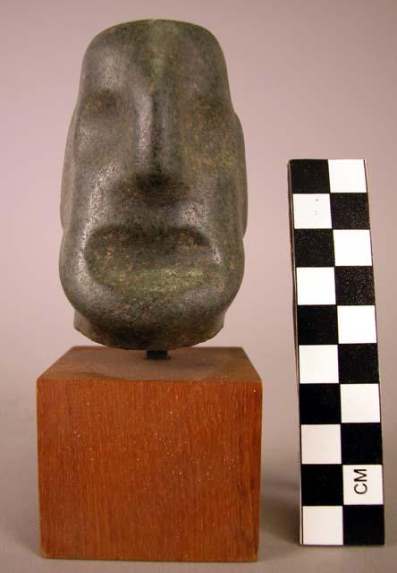 Polished serpentine head with shallow hollows depicting eyes and mouth.