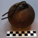 Coconut shell container, 2 perforations at top, braided veg fiber string