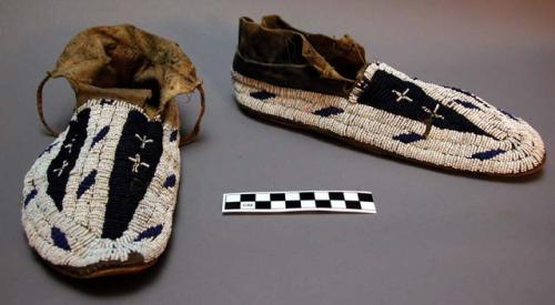 Pair of moccasins with rawhide soles. blue and white bead trimming