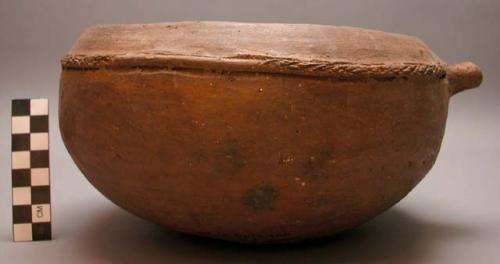 Red pottery vessel with small handle on one side. Chikalango