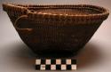 Basket; footed base; slightly flaring sides; wood rim; patterned weave